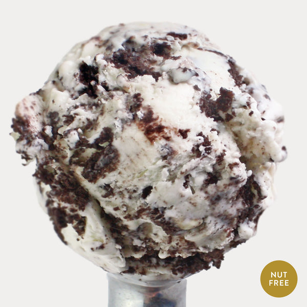 Scoop of cookies and cream ice cream with nut free labeled on the bottom. 